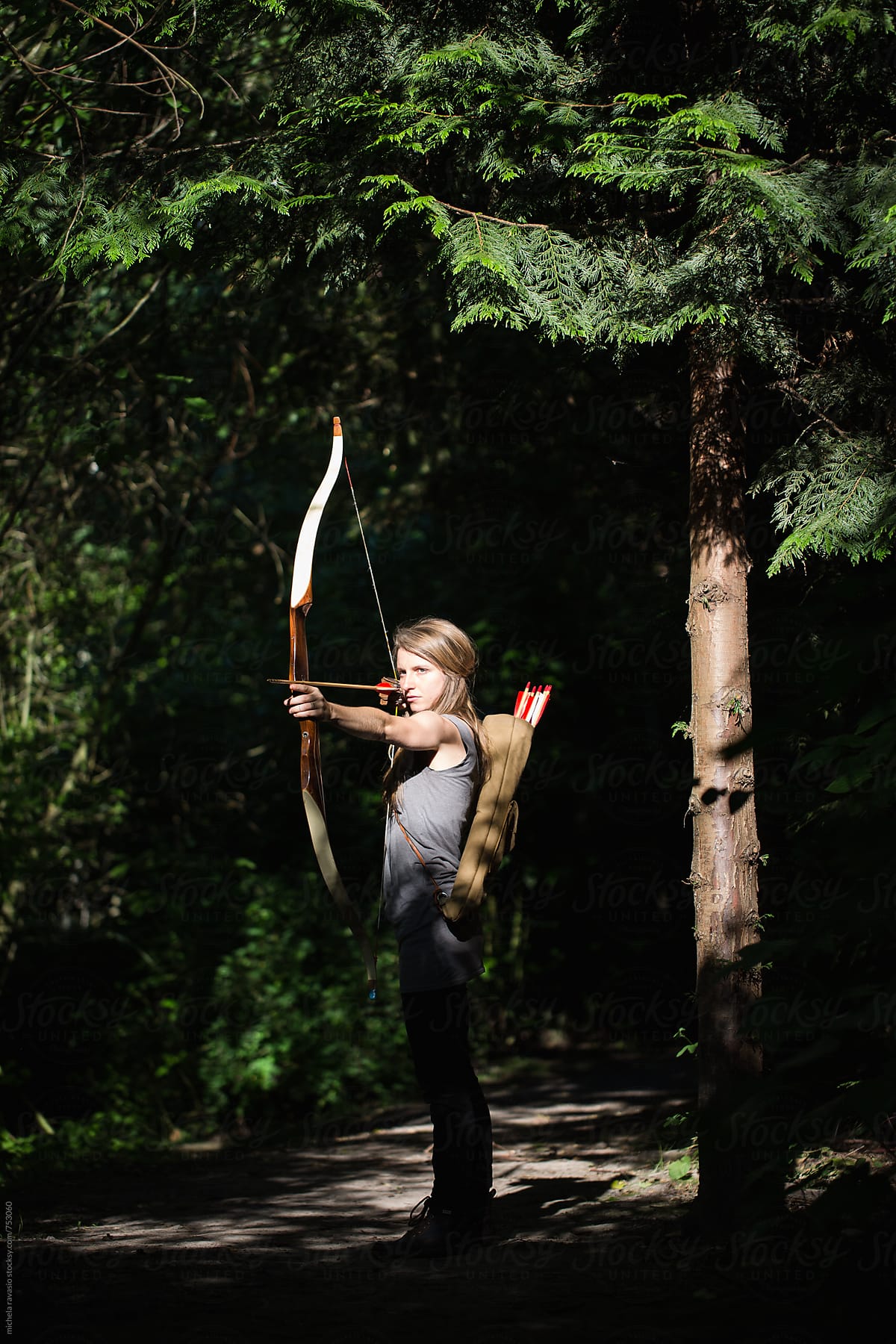 Young woman aiming with archery