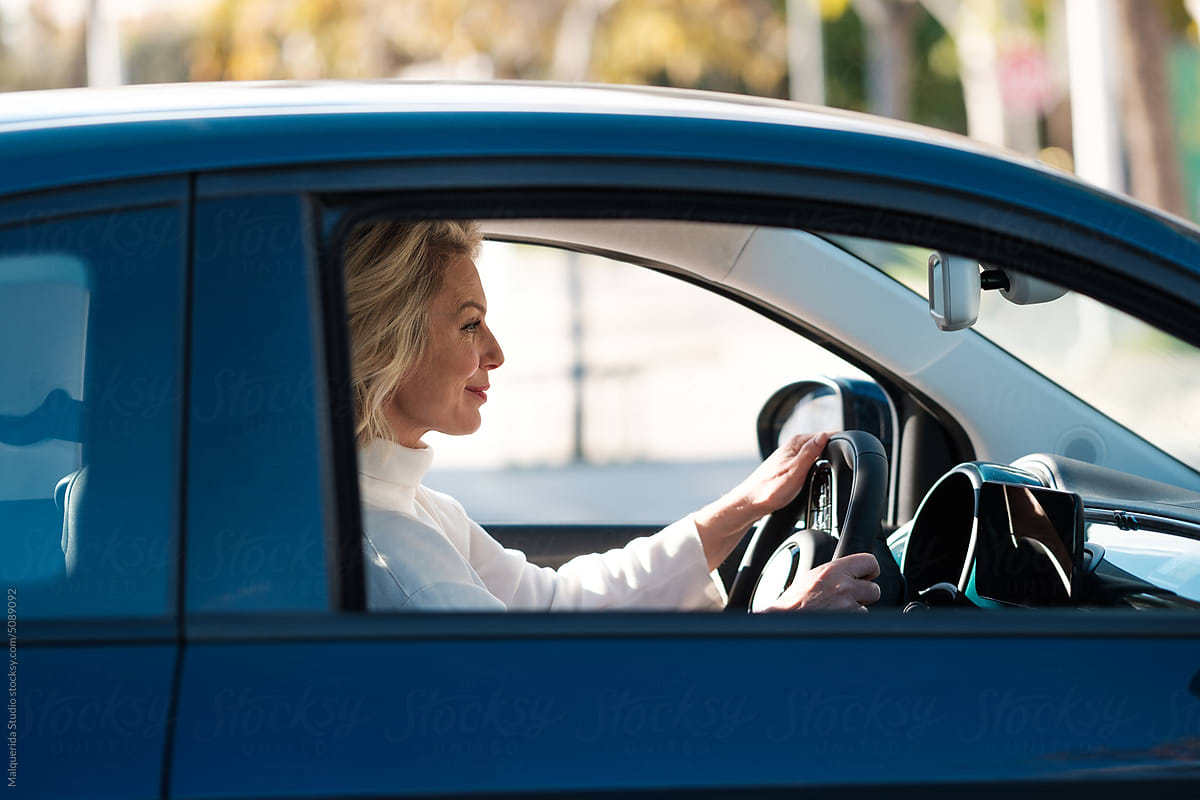 Woman holding handwheel while driving a car