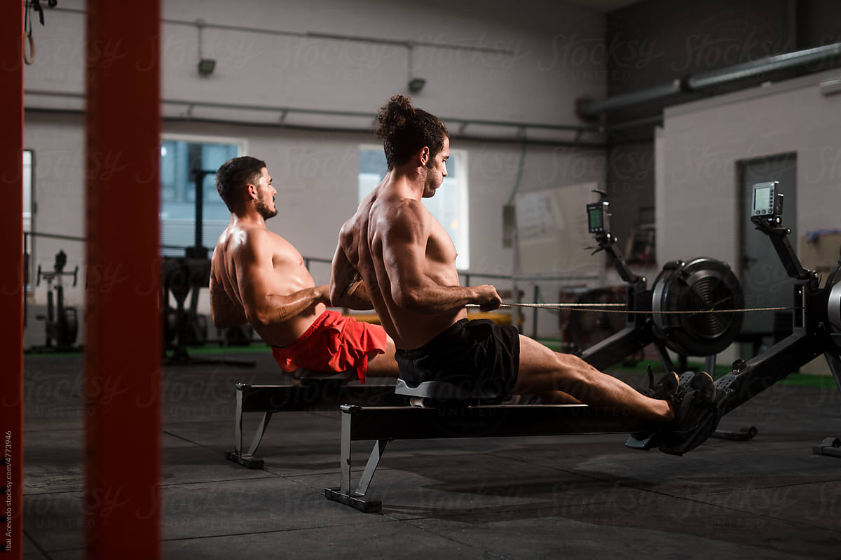 Two athletes working out on rowing machine