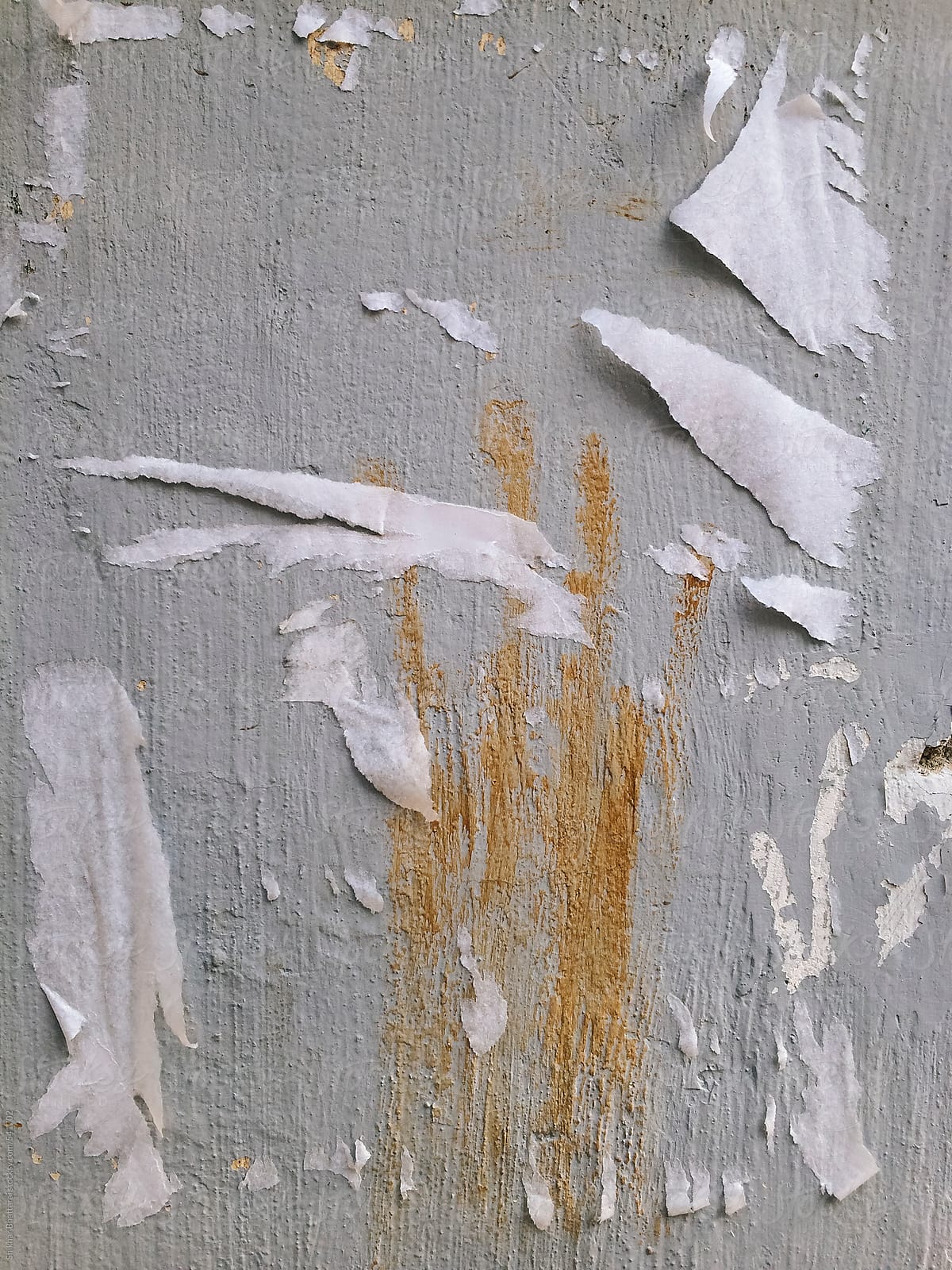 Scraped off paper from a wall with a print of a hand.