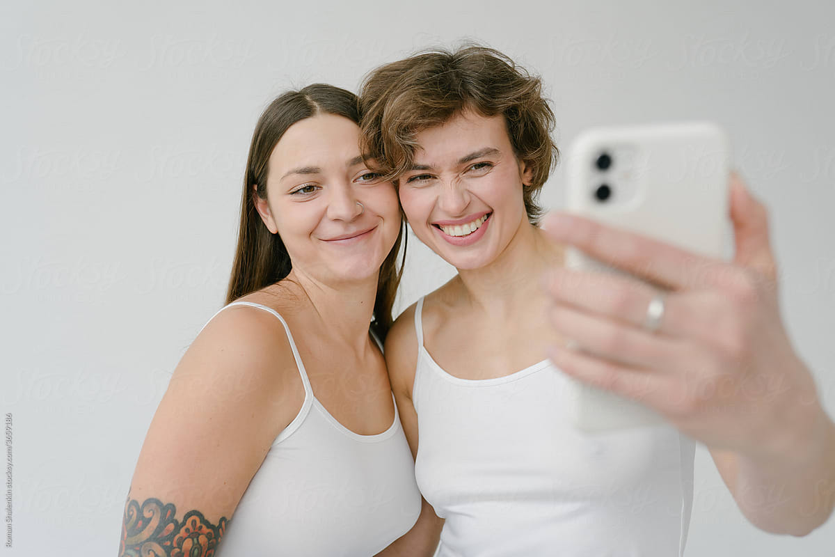 Smiling young women taking selfie on smartphone