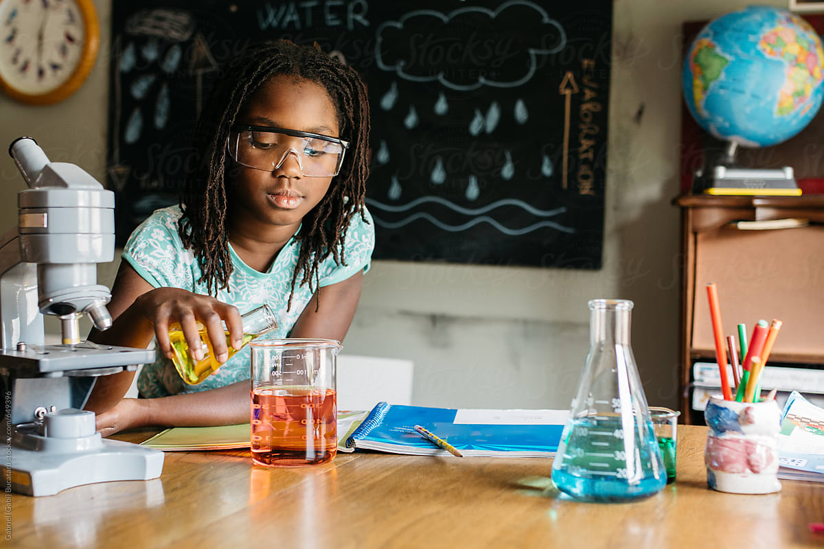 African American girl doing a chemistry experiment in science class