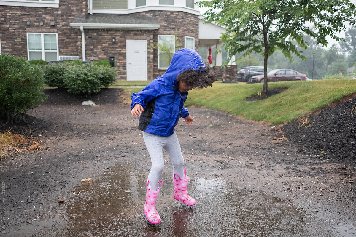 Toddler jumping in puddles