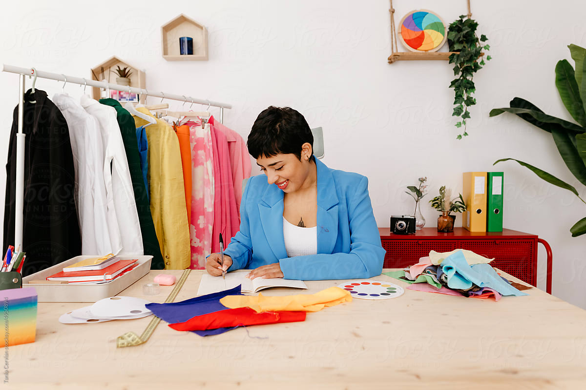 Glad Hispanic woman creating cloth sketch