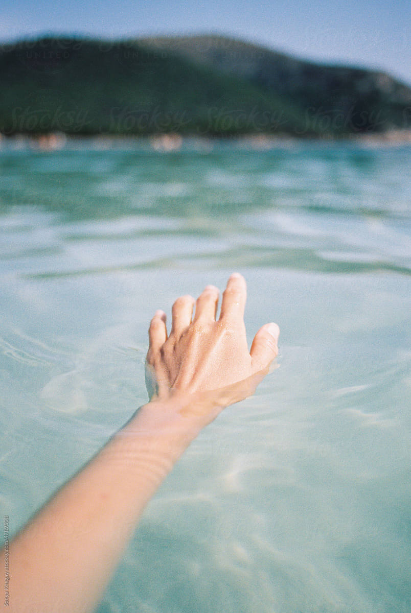 female hand in sea water
