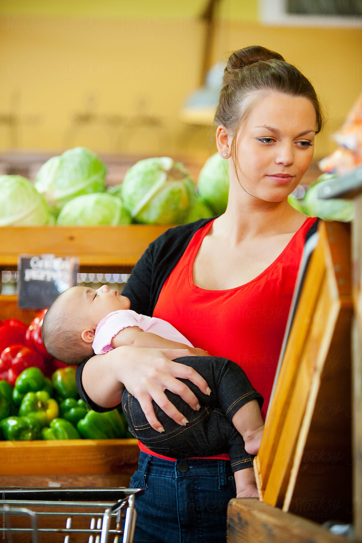Market: Mother Holds Sleeping Baby While Shopping