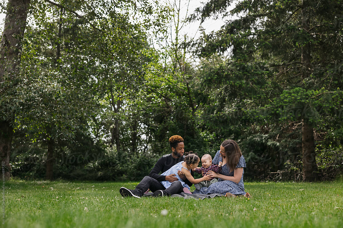Young family on blanket together in the park.
