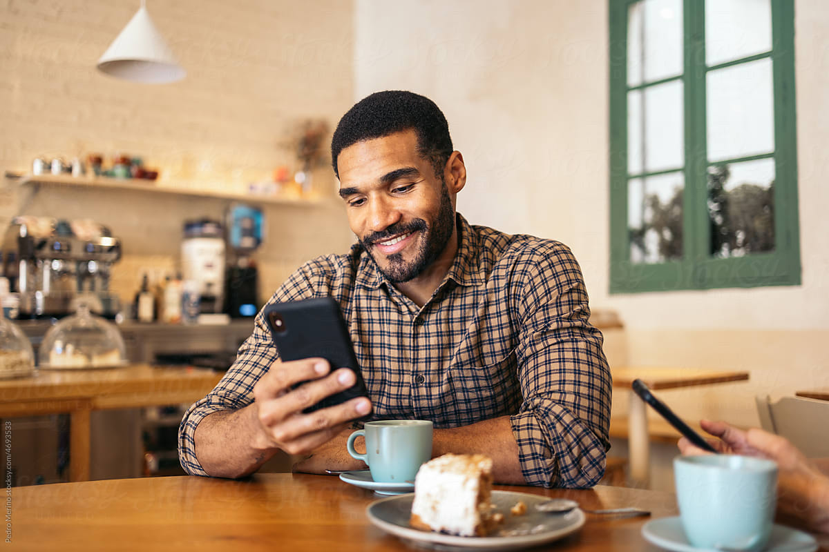 Handsome black man using smartphone in a cafe