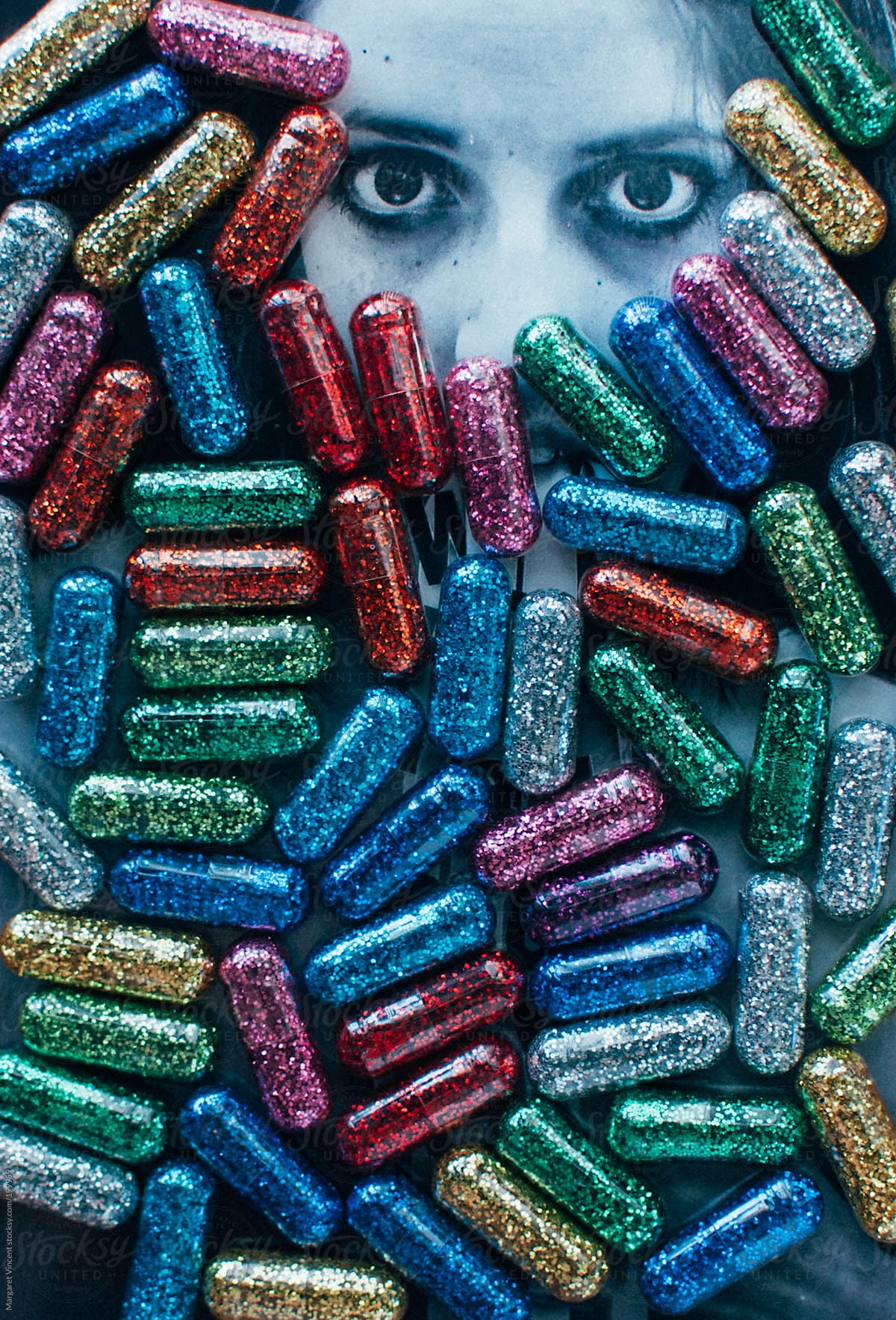 multicolor glitter pills cover a photographed face