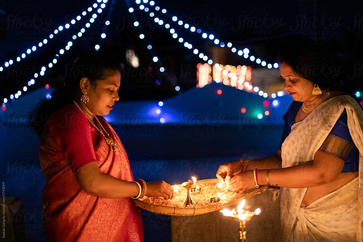 Happy women celebrating diwali with oil lamps
