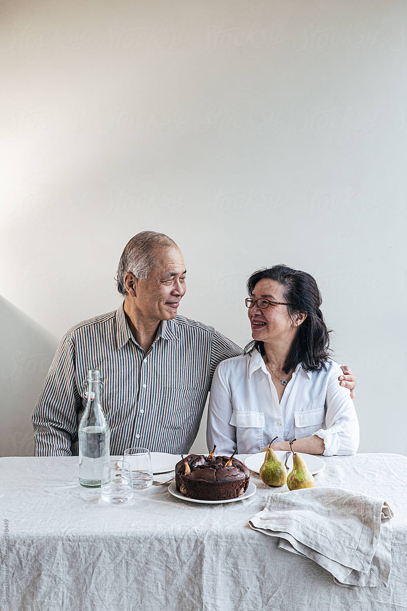 An elderly couple sitting at dining table