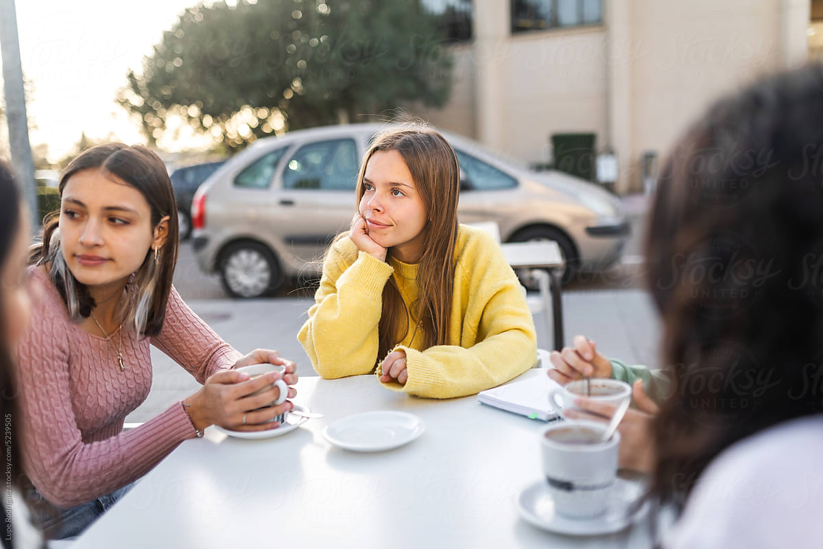 young teenage girl friends sitting in a coffee shop
