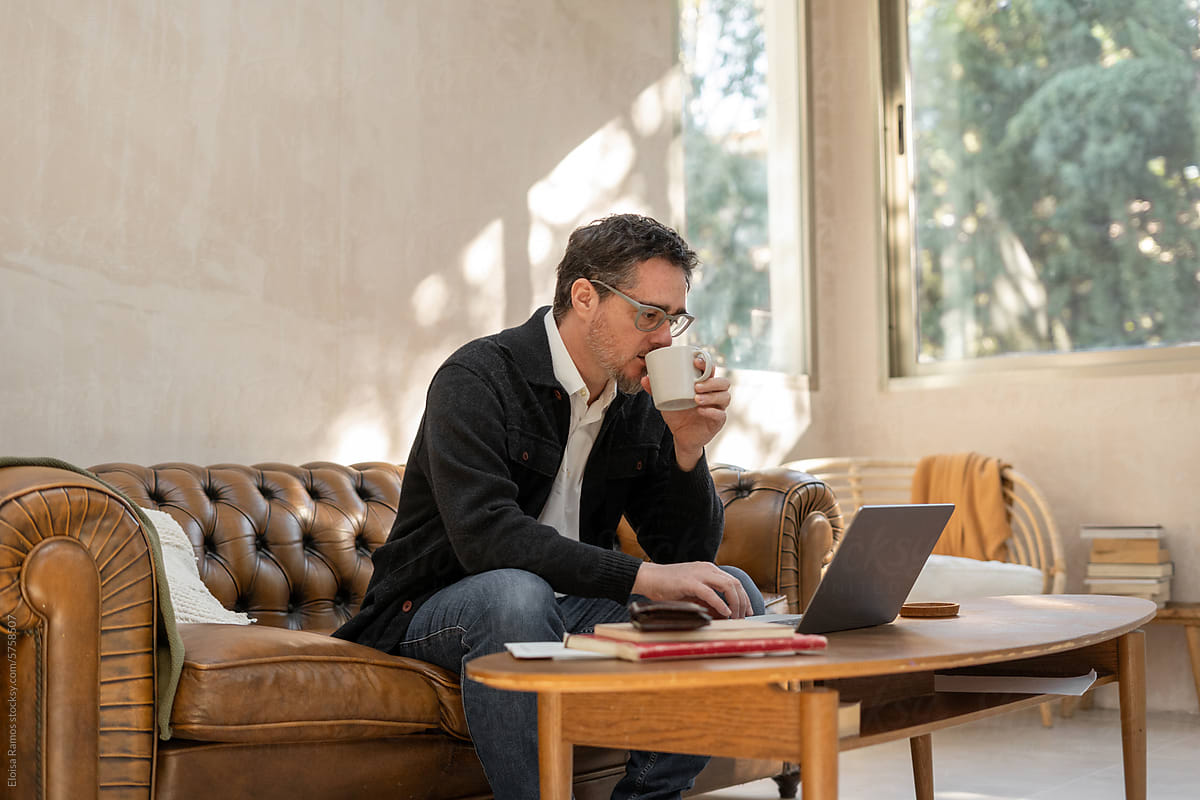 Mature Man Working Remotely drinking coffee