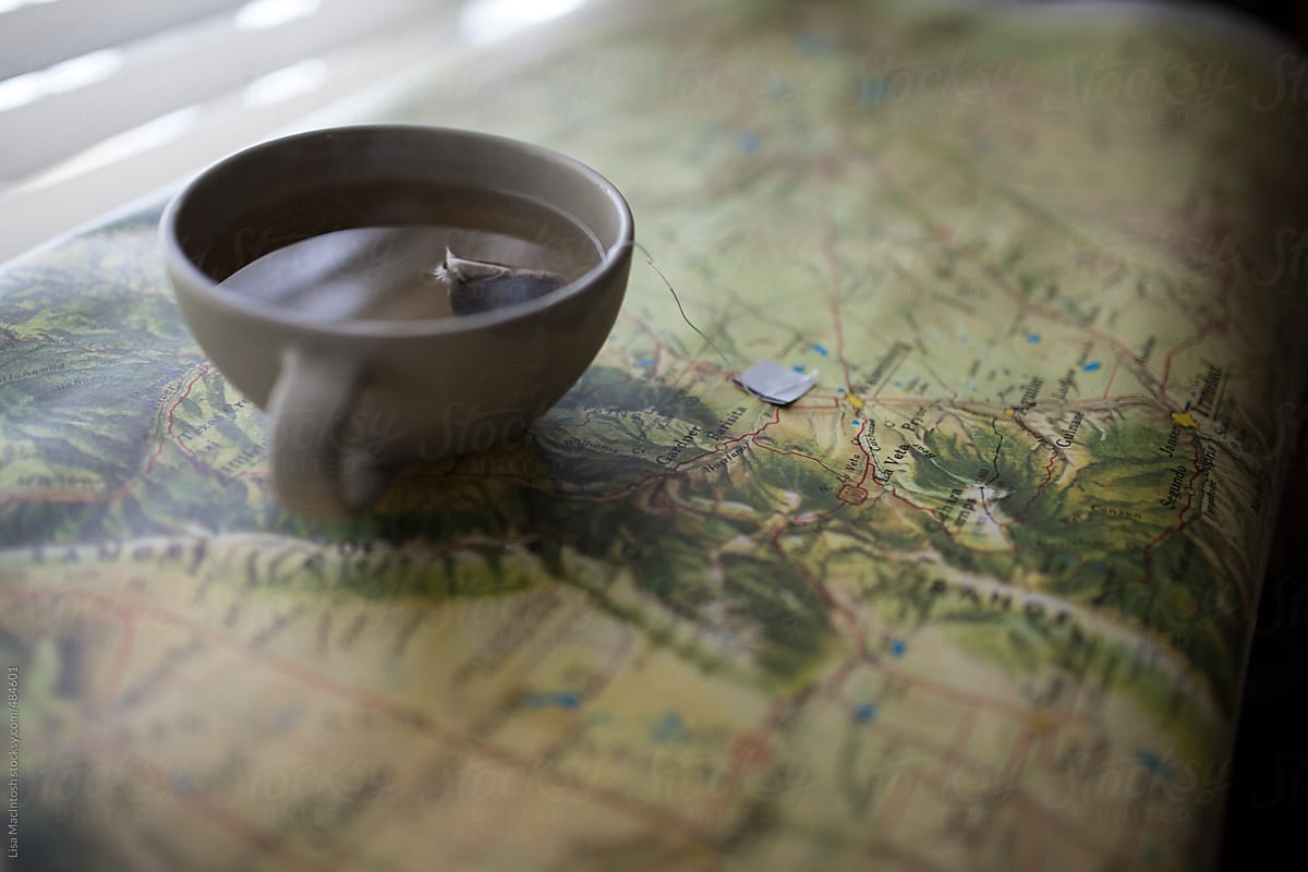 handmade tea cup sitting on vintage map