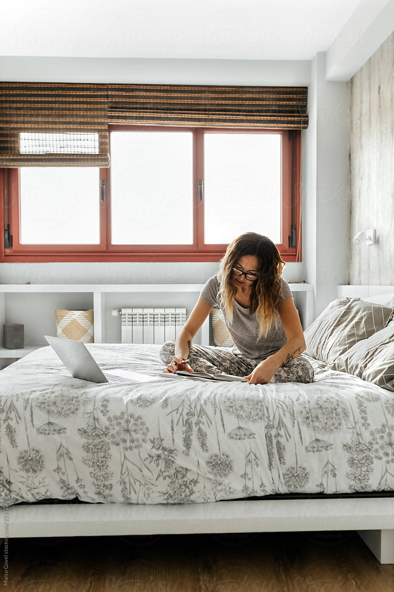 Woman working in bed