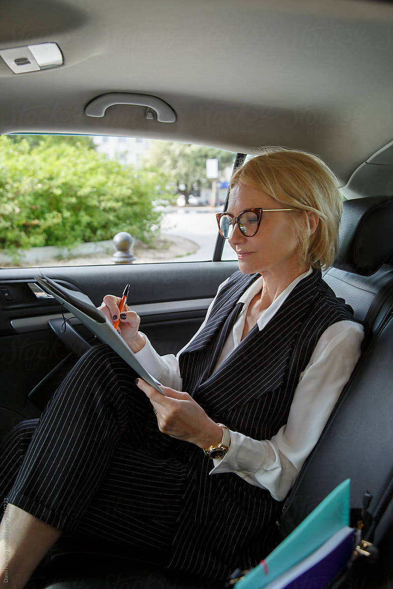 Businesswoman reading documents while riding on car