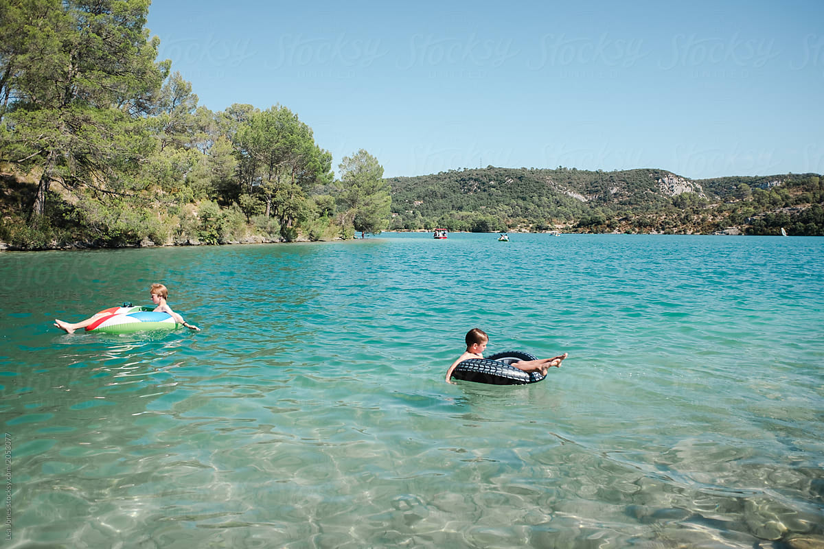 two boys relaxing on flats in a lake in Provence