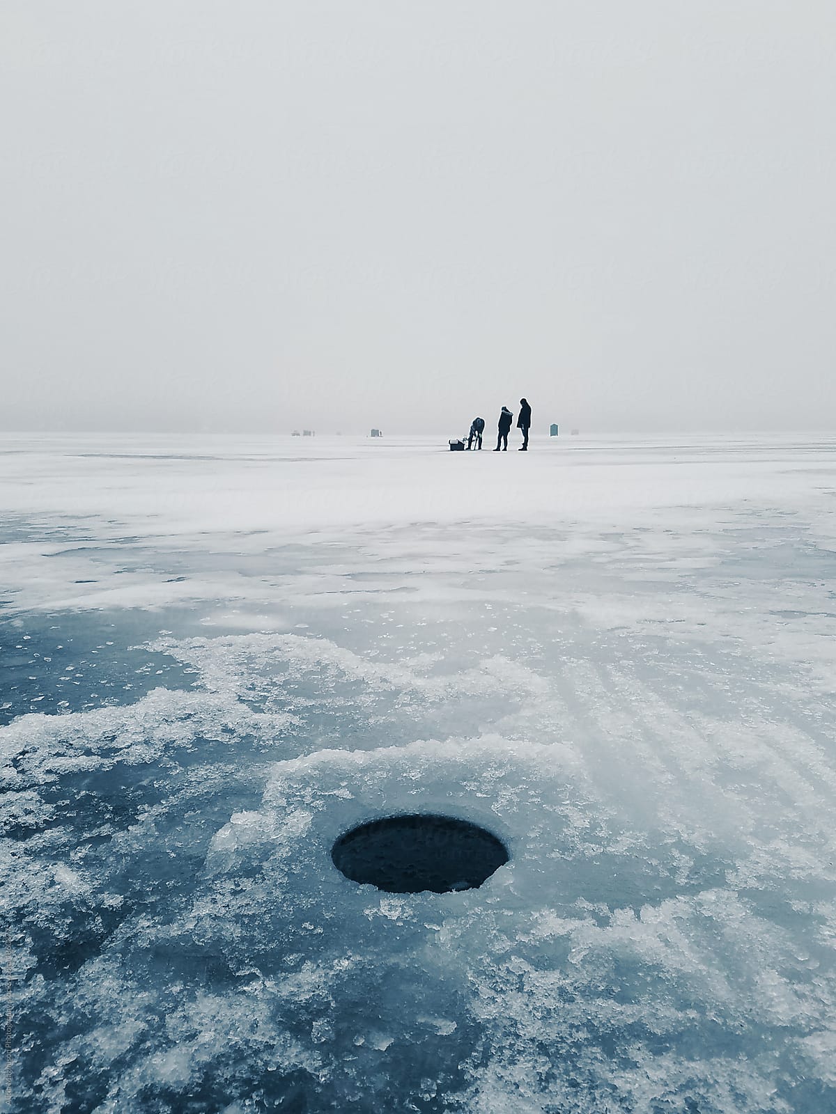 Fishermen Drilling Ice Fishing Holes On Frozen Lake by Stocksy Contributor  Alicia Magnuson Photography - Stocksy
