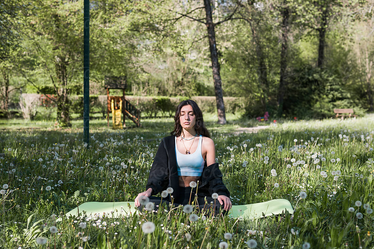 Young Woman Doing Yoga In Meditation Garden by Stocksy