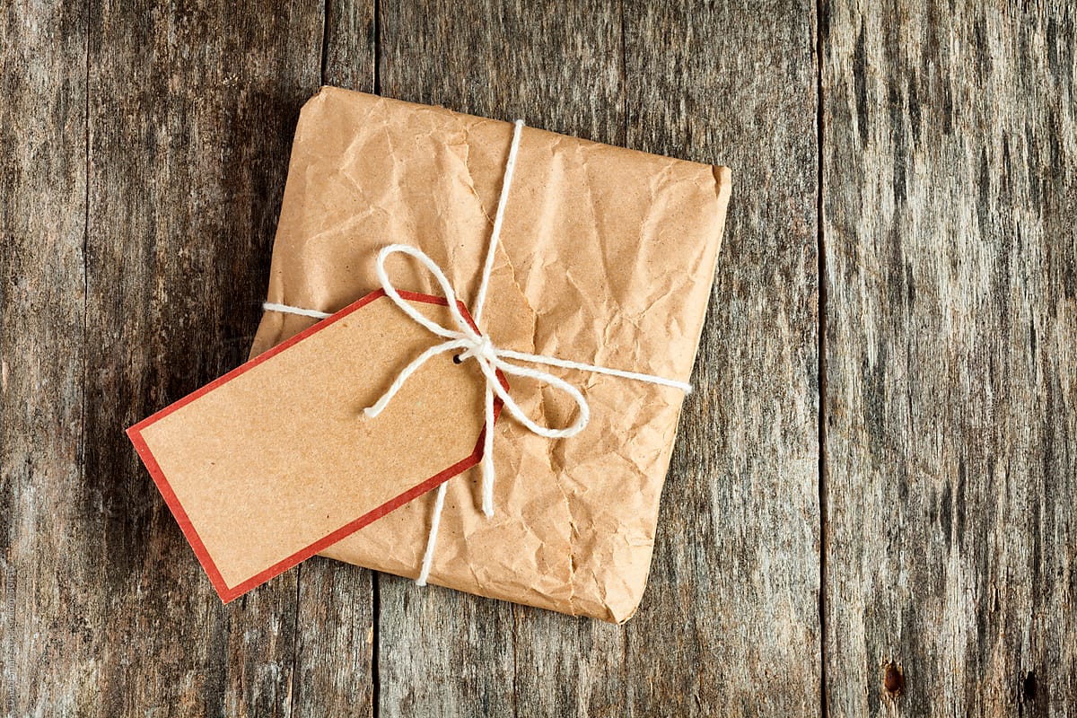 Package wrapped in wrinkled brown paper and blank tag