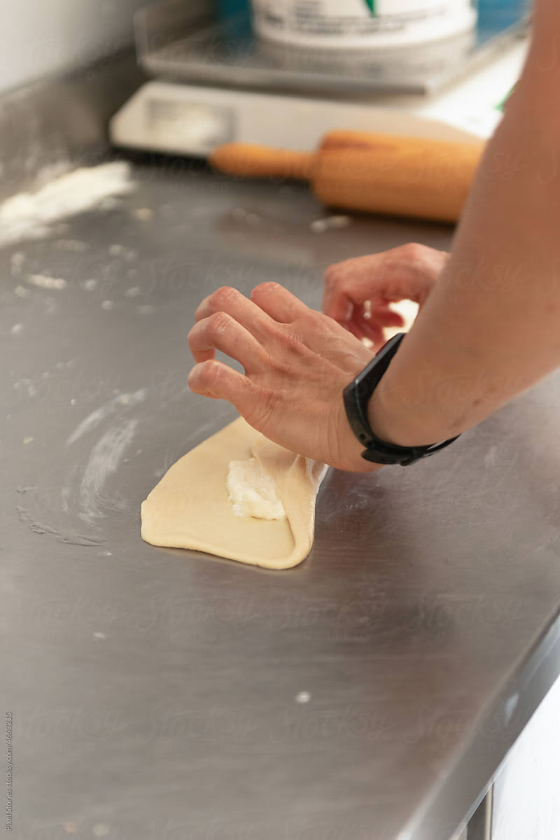 Baker making dough pastry in small bakery