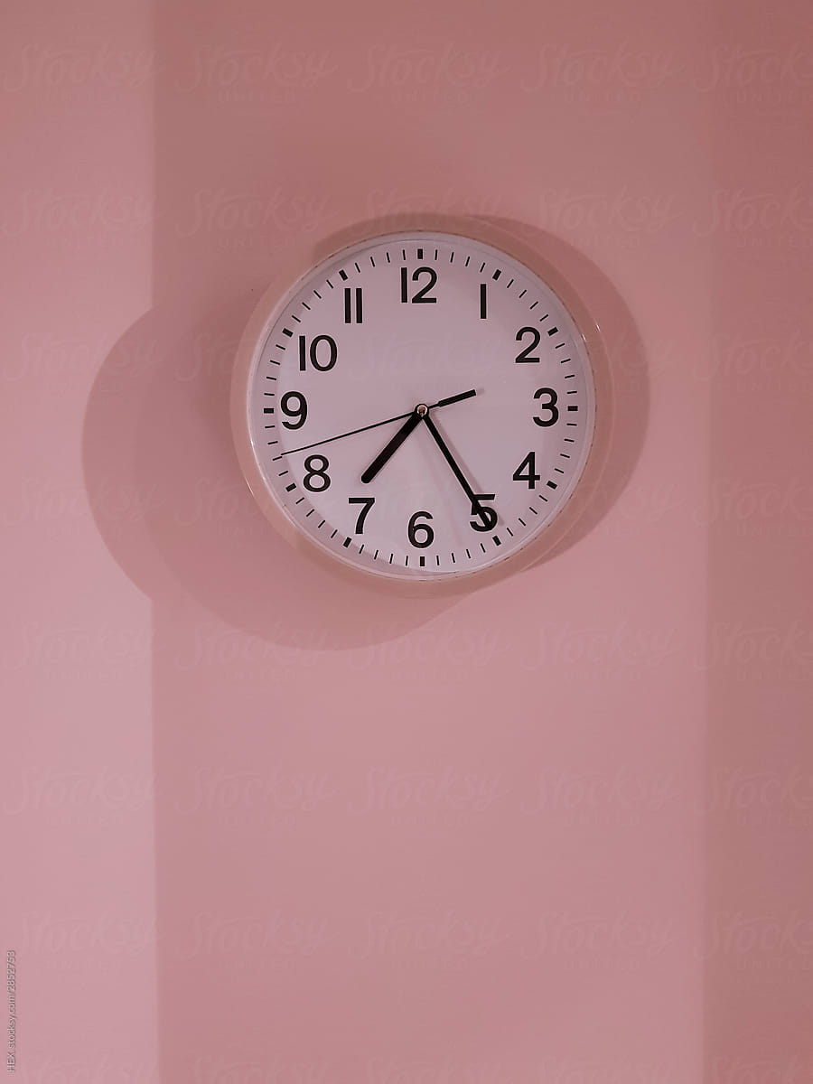 Pink Clock on a Matching Color Wall with different gradations made by Shadows. Time Concept