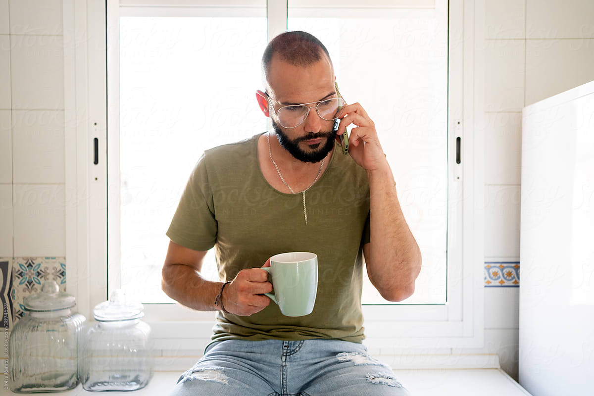 Man calling by phone at kitchen