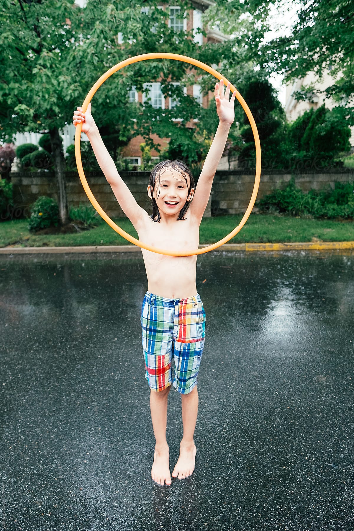 Young Boy Plays With Hula Hoop in Rain