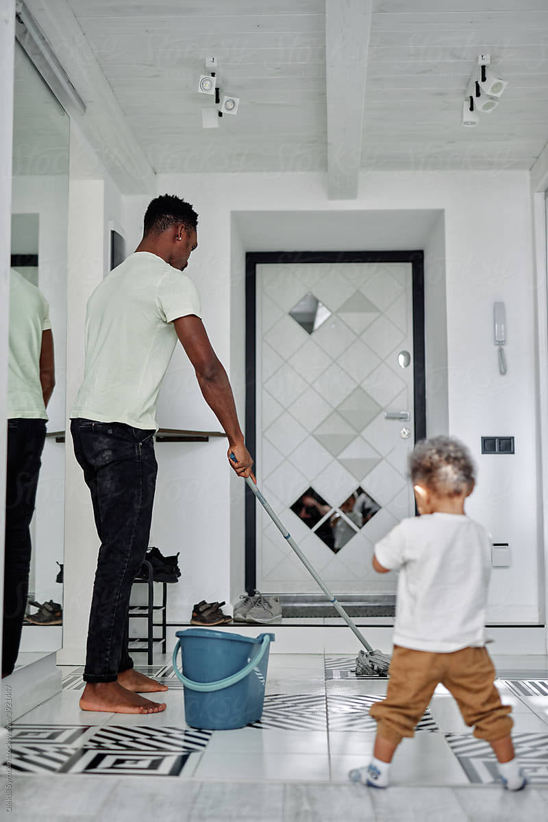 Man with kid cleaning floor at home