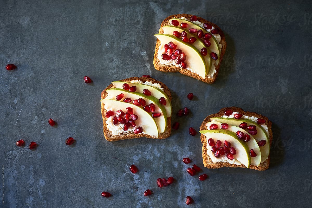 Health and wellness breakfast toasts with pomegranate, pear and cream cheese