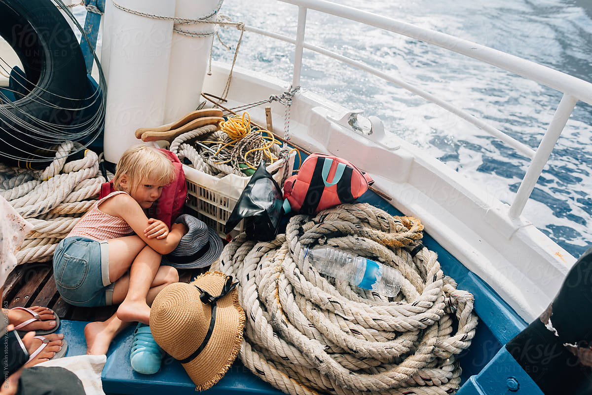 Little Girl Laying On The Boat Deсk Floating In The Sea by