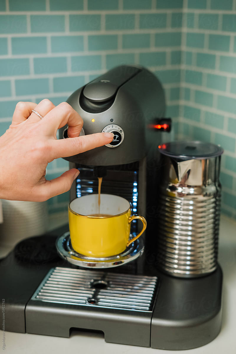 Anonymous woman brewing coffee in yellow cup