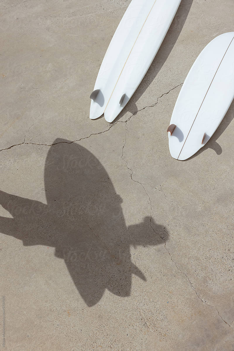 shadow of person holding surfboard