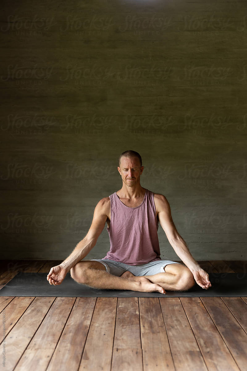 Adult man meditating in yoga studio
