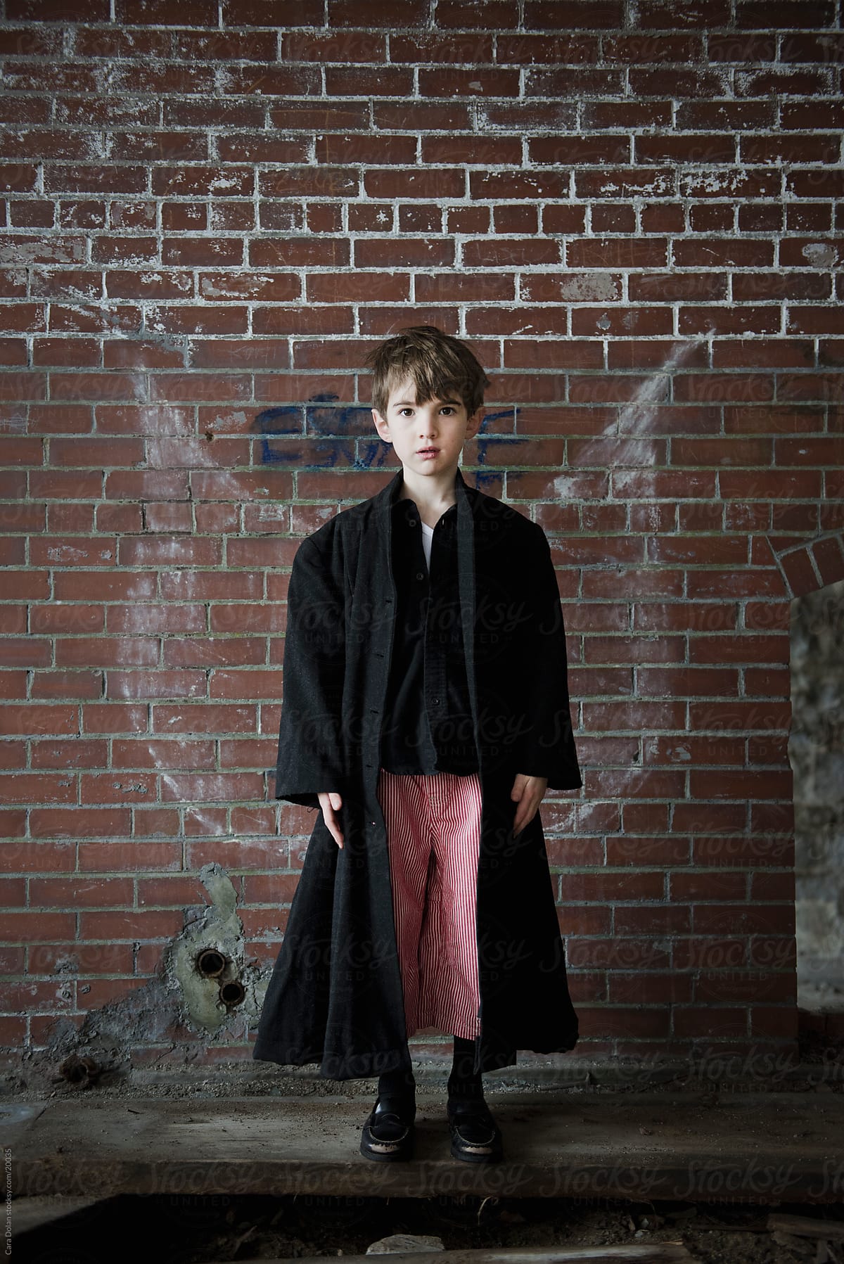 Boy has graffiti wings in an abandoned brick building