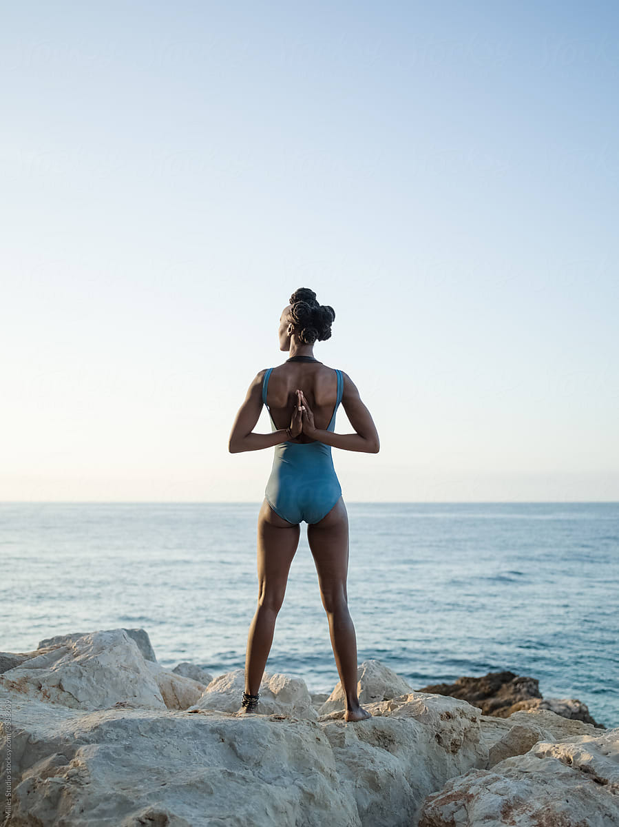 Black woman doing yoga and admiring sunrise sky