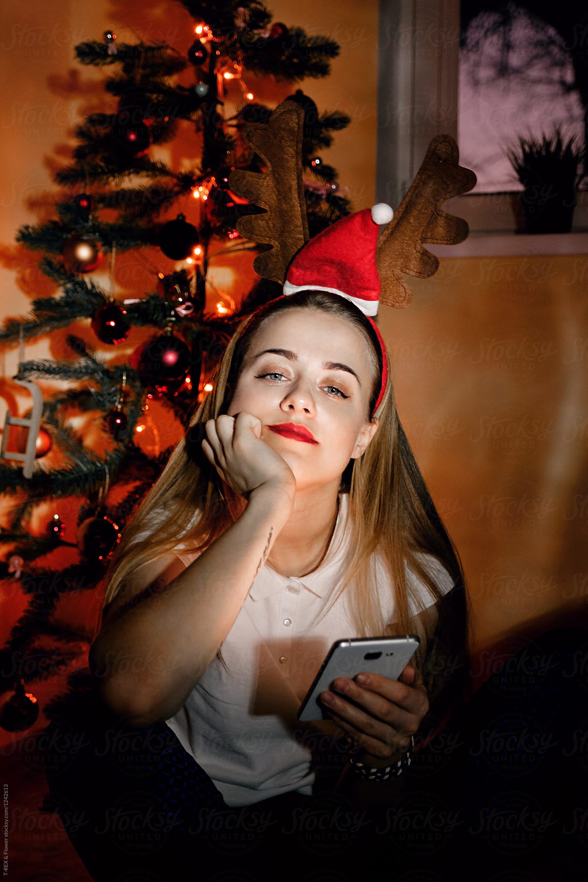 Young pensive girl with phone in Christmas