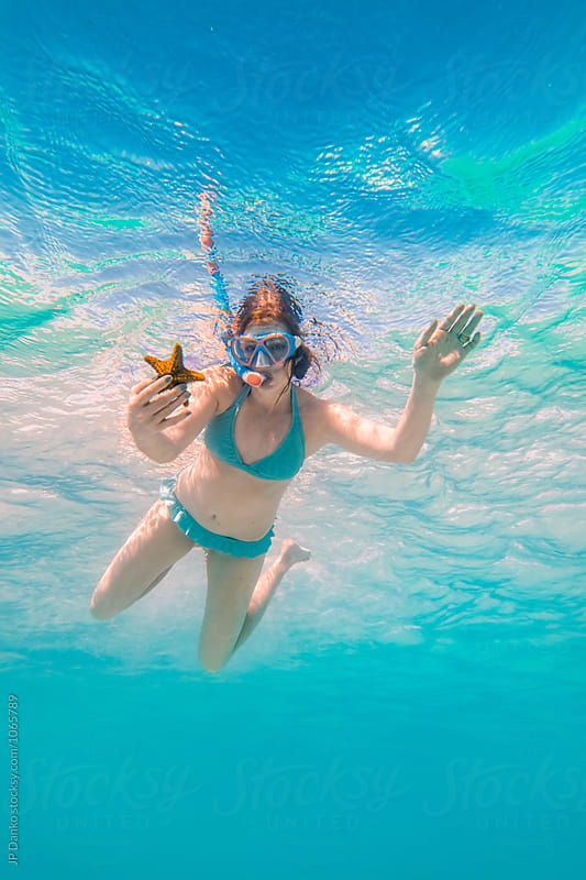Woman Holding Starfish Swimming Underwater at All Inclusive Caribbean Resort White Sand Beach