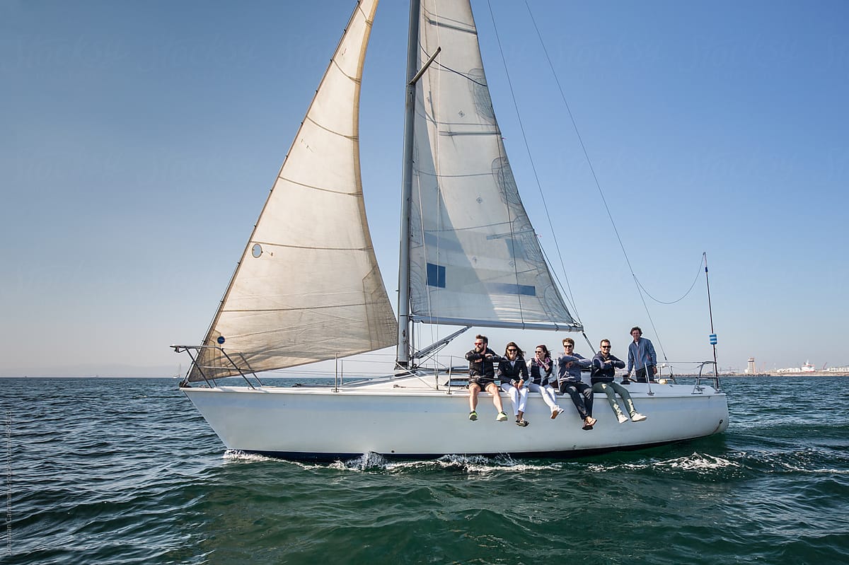 Crew of friends on a sailboat yacht going for a cruise on the ocean with the sail up.tif