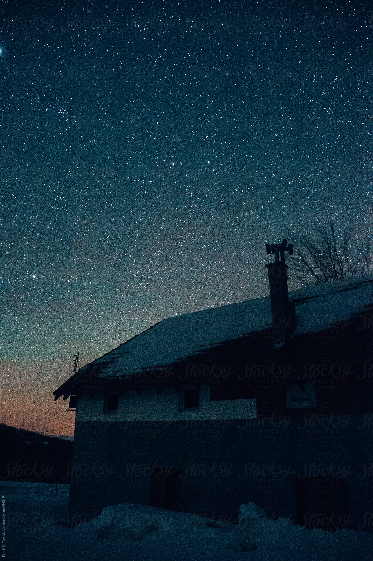 Mountain lodge sillouethe under a starry sky