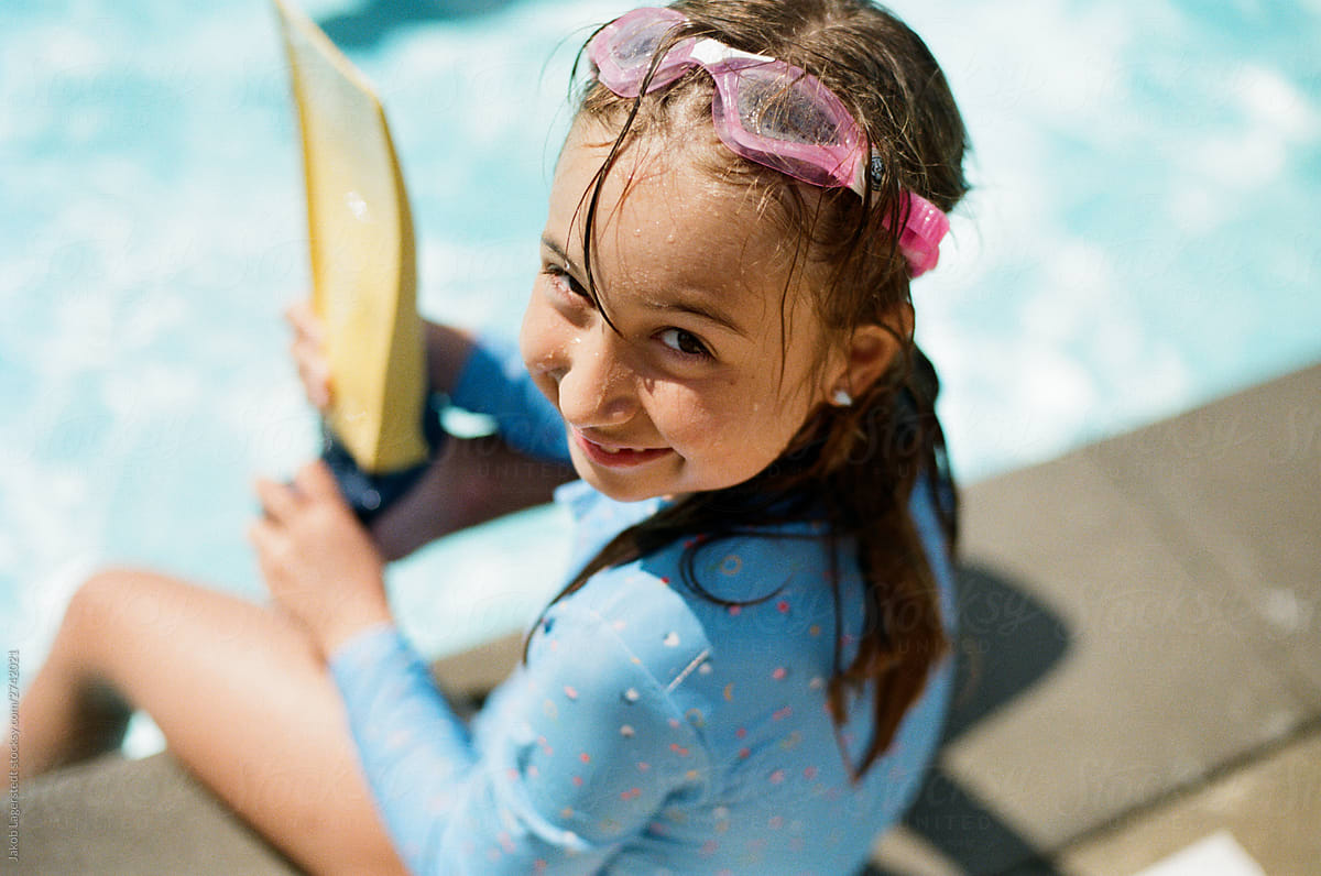 Cute Young Girl Sitting By The Side Of A Pool Wearing Swim Goggles By 2661