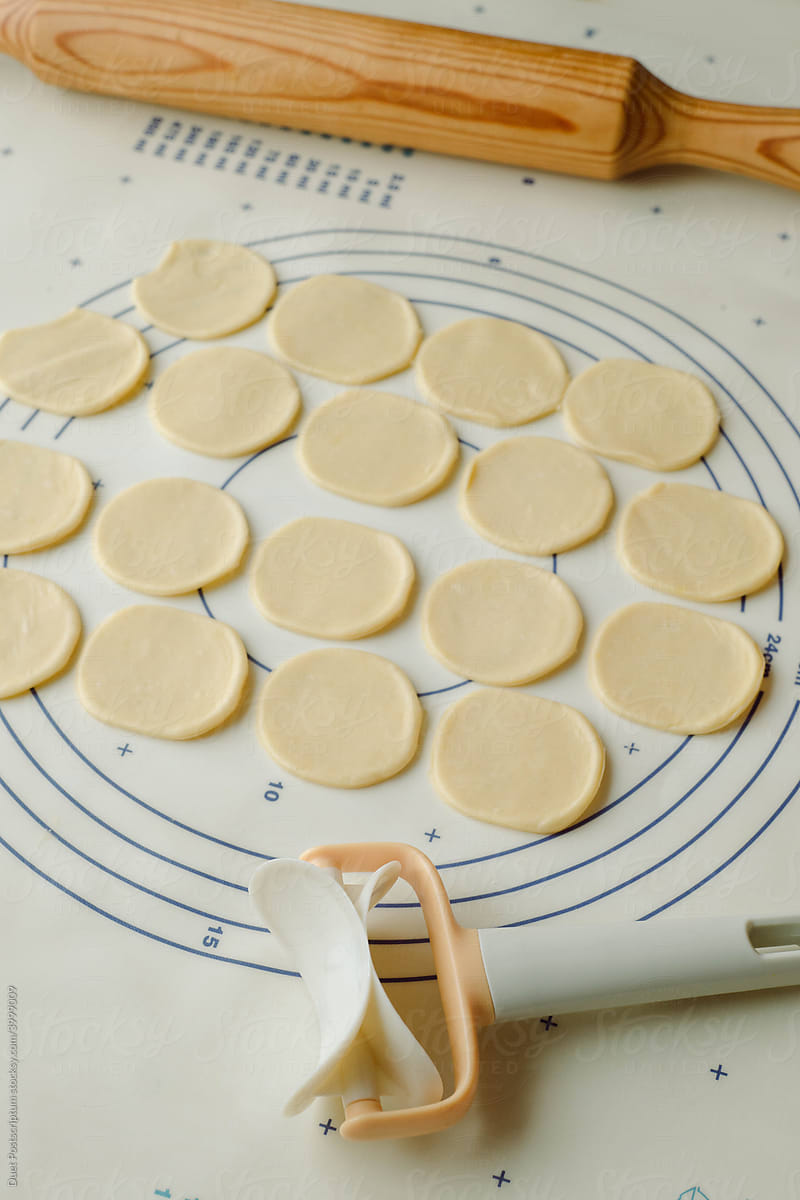 Dough circles cut for dumplings on a baking mat