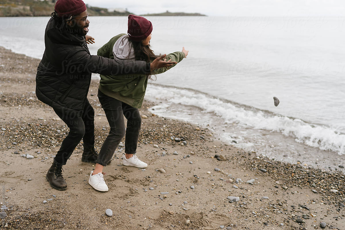 Couple Throwing Pebbles on the Beach