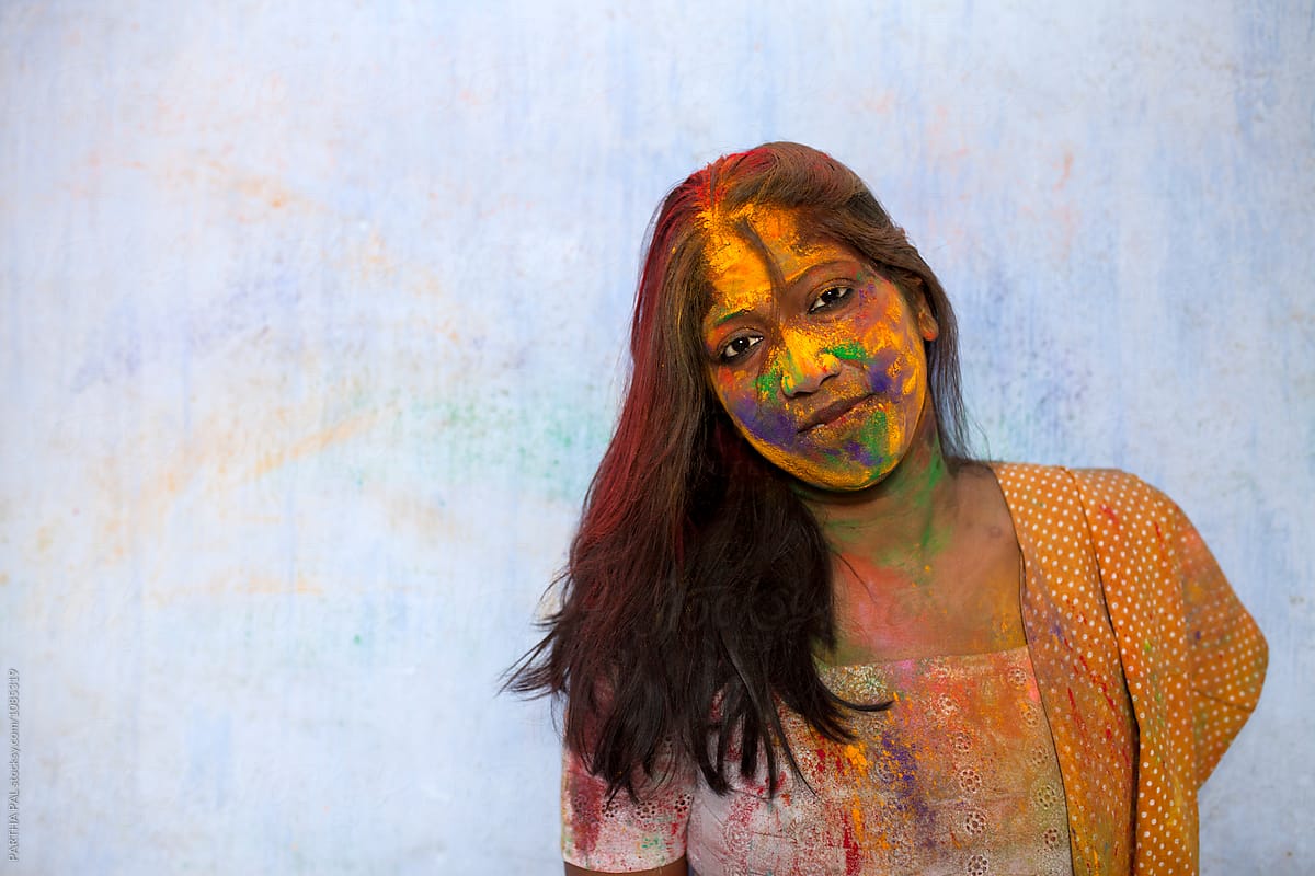 Indian woman with colorful face in Holi festival
