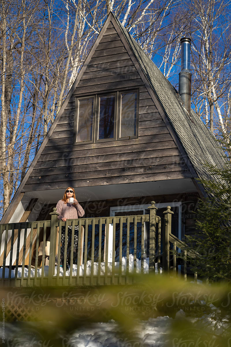 Woman at Cottage in Woods on Sunny WInter Day