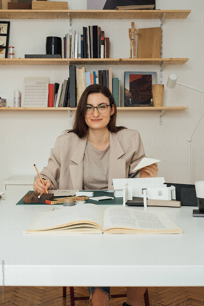 Female Architect Working in Studio and Smiling at Camera