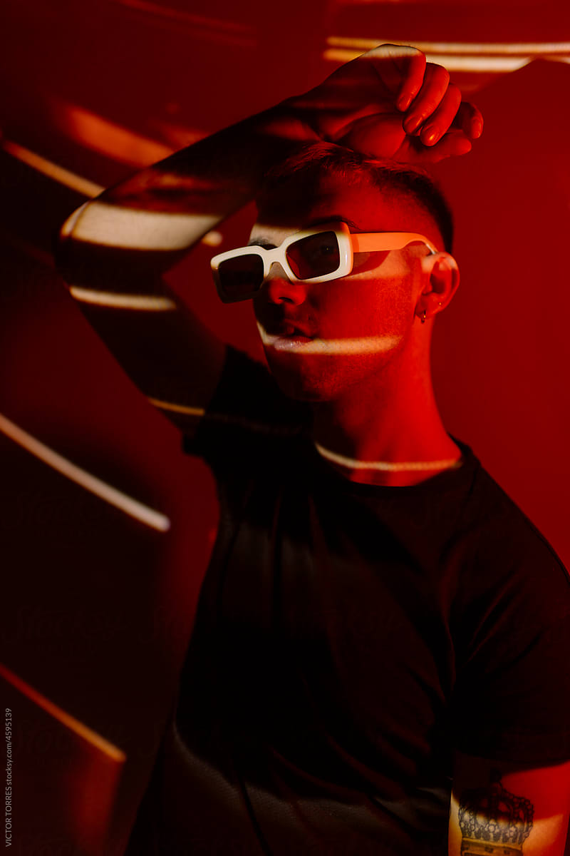 Stylish man in sunglasses in neon light