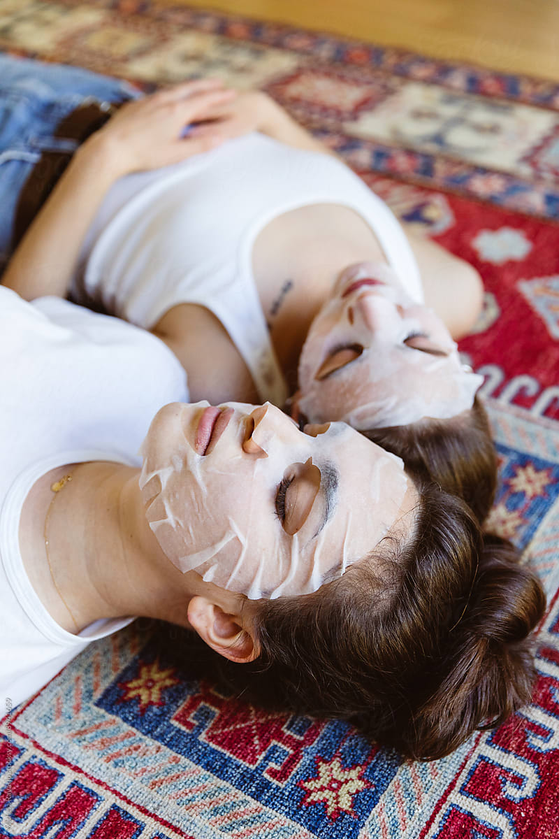 Two girlfriends with paper beauty mask
