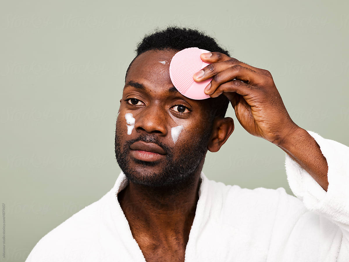 Man using brush pad as part of his skincare routine