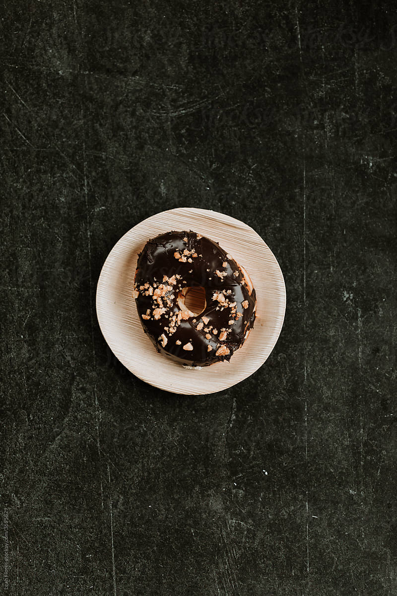 Chocolate Donut with Peanuts on Plate